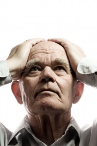 shutterstock_11020279 old man holding his head in his hands
