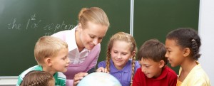 teacher looking at globe with children