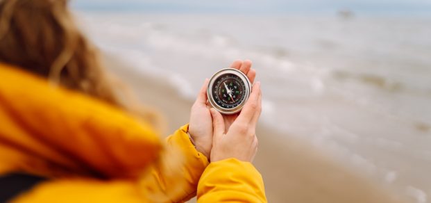 Woman,Traveler,Looking,For,Directions,With,A,Compass,On,The