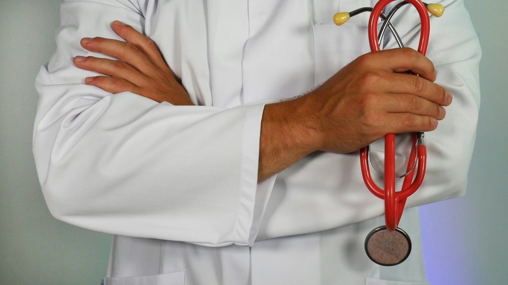 Person in a white coat holding a stethoscope