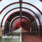 View up and enclosed tunnel with a slow sign painted on the ground.