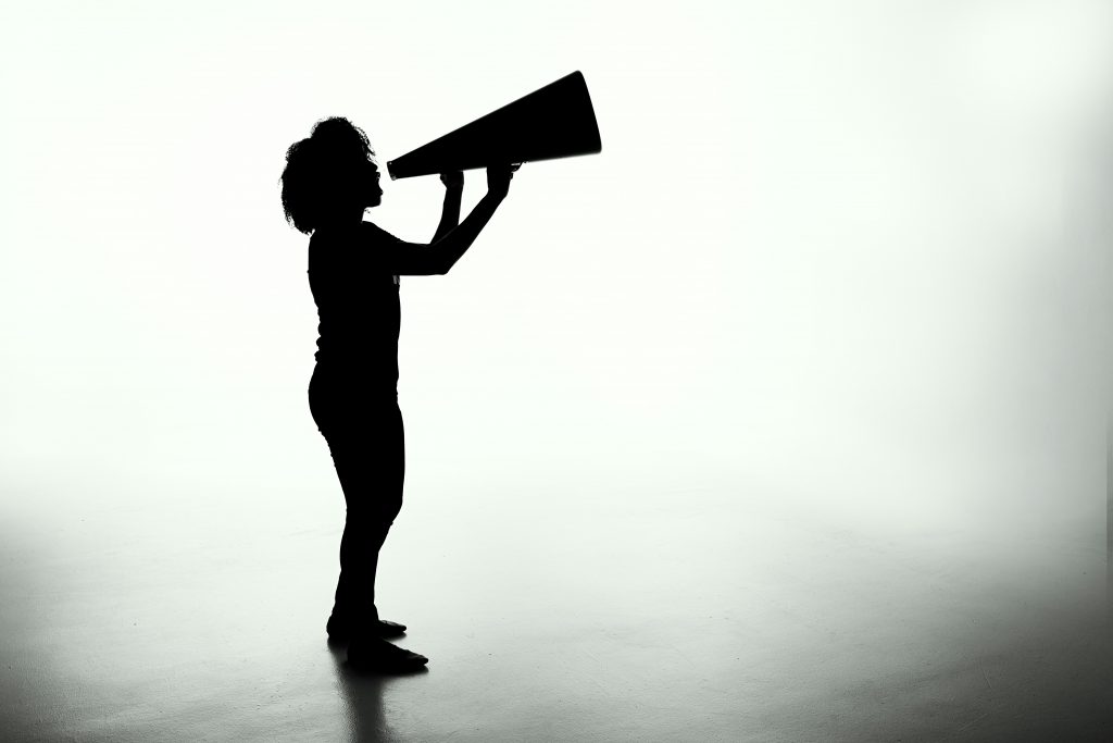 silhouette of woman holding megaphone